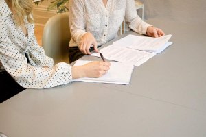 Woman at desk looking at questions on paper